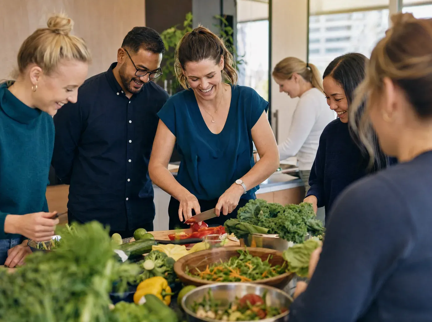 Workplace colleagues preparing a healthy meal together during a cooking demonstration